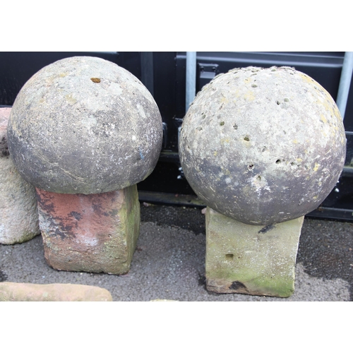 1094 - Two 19th century spherical architectural finials, each with a flattened underside upon associated sa... 