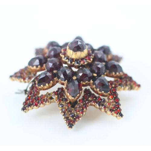 172 - A 19th century style Bohemian brooch, the untested mixed cut garnets designed as star with raised ce... 