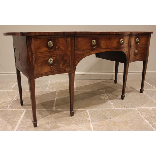 930 - A George III Sheraton style mahogany sideboard, the serpentine crossbanded top over a central silver... 