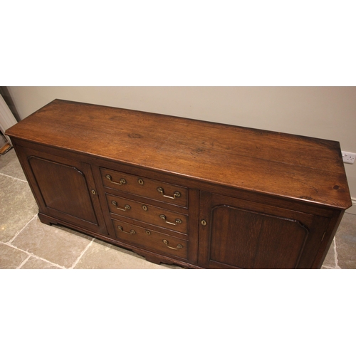 936 - A 19th century oak dresser base, the rectangular top with canted front corners over a central bank o... 