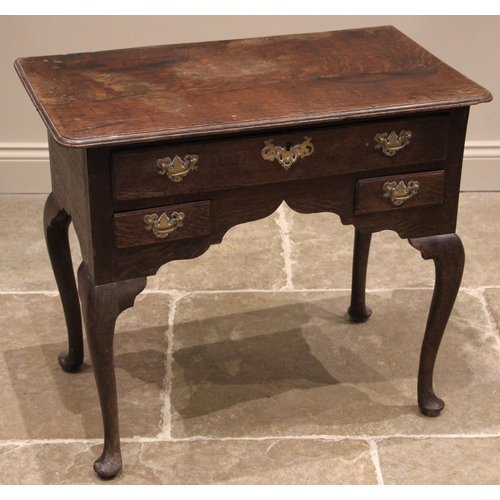 939 - A George III oak lowboy, the rectangular moulded top with rounded front corners over one long and tw... 