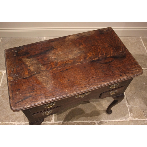 939 - A George III oak lowboy, the rectangular moulded top with rounded front corners over one long and tw... 