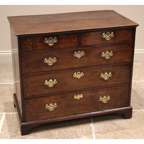 940 - A George II oak chest of drawers, the slightly oversailing top above an arrangement of two short and... 