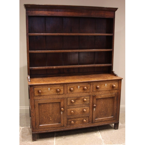 942 - A late George III Welsh honey oak dresser, the plate rack with a moulded cornice and three shelves, ... 