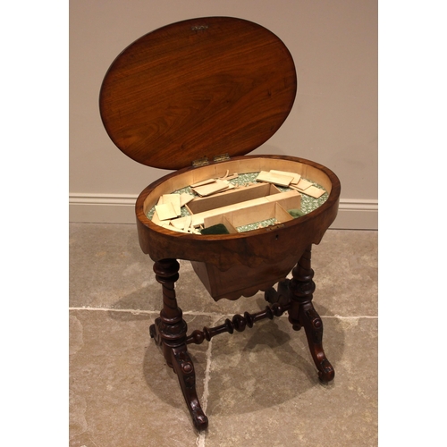 965 - A Victorian figured walnut sewing table, the quarter veneered oval top opening to a compartmented in... 