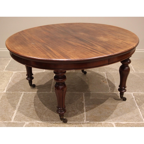 976 - A Victorian mahogany extending dining table, the oval top upon acanthus baluster legs culminating in... 