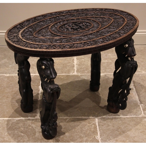 984 - A Ceylonese carved hardwood occasional table, the oval top carved in deep relief with radiating band... 