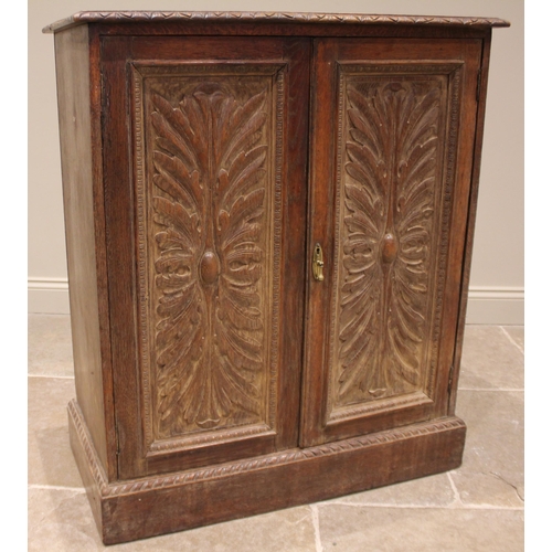 985 - A 17th century style carved oak cupboard, 19th century, the rectangular moulded top over a pair of a... 