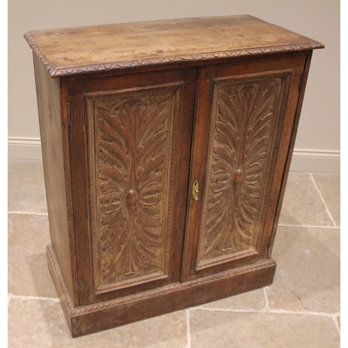 985 - A 17th century style carved oak cupboard, 19th century, the rectangular moulded top over a pair of a... 