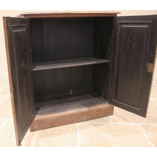 985 - A 17th century style carved oak cupboard, 19th century, the rectangular moulded top over a pair of a... 