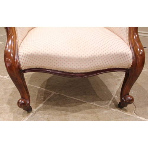 988 - A Victorian mahogany framed balloon back armchair, later re-upholstered, the button back extending t... 