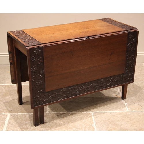 997 - A 19th century carved oak gate leg dining table, the rectangular drop leaf top with a carved trailin... 