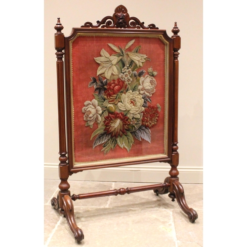 1015 - A Victorian mahogany framed stump work cheval firescreen, the open work scroll crest centred with a ... 