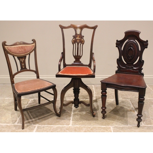 1020 - An Edwardian inlaid mahogany revolving music chair, the pierced and foliate inlaid splat back extend... 