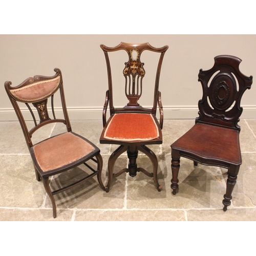 1020 - An Edwardian inlaid mahogany revolving music chair, the pierced and foliate inlaid splat back extend... 