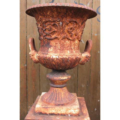 1109 - A pair of Victorian style cast iron urns on stands, the urns of campana form, each 62cm high, the re... 