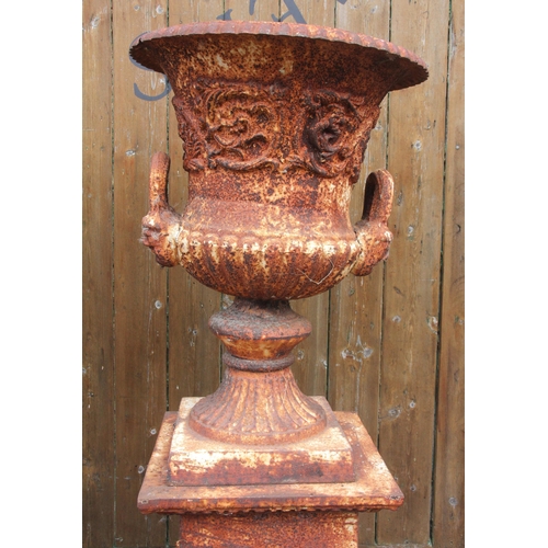 1109 - A pair of Victorian style cast iron urns on stands, the urns of campana form, each 62cm high, the re... 