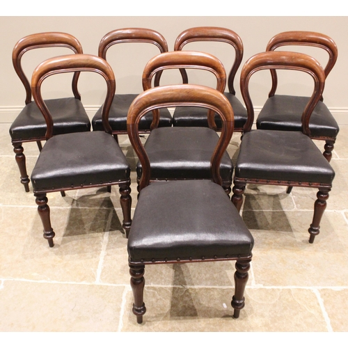 971 - A set of eight Victorian mahogany balloon back dining chairs, each with a curved rail back over a st... 