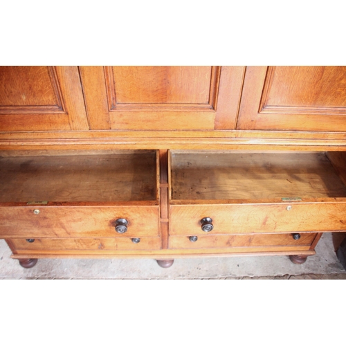 999 - A 19th century golden oak housekeepers cupboard, the oversailing cornice applied with acorn pendants... 