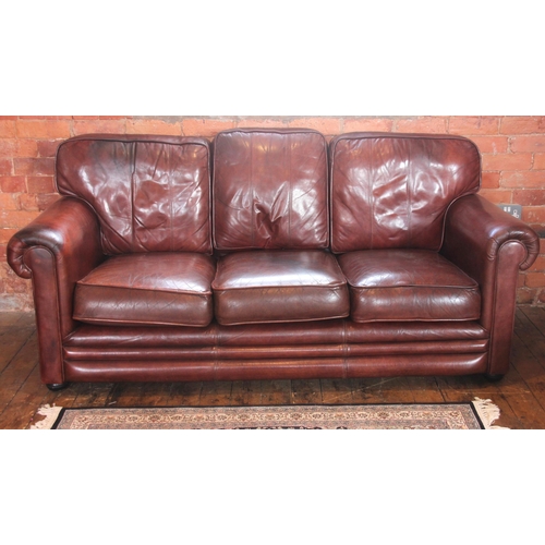 1055 - A leather sofa by Thomas Lloyd, late 20th/early 21st century, the padded scrolled arms enclosing thr... 