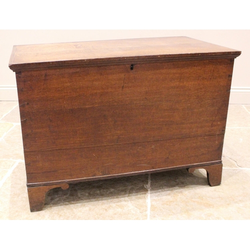 980 - A 19th century oak blanket chest, the hinged cover opening to a vacant interior, upon bracket feet, ... 