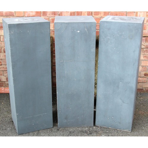 1071 - A set of three composite patio pedestals, of plain cubic rectangular form, the hollow pedestals reve... 