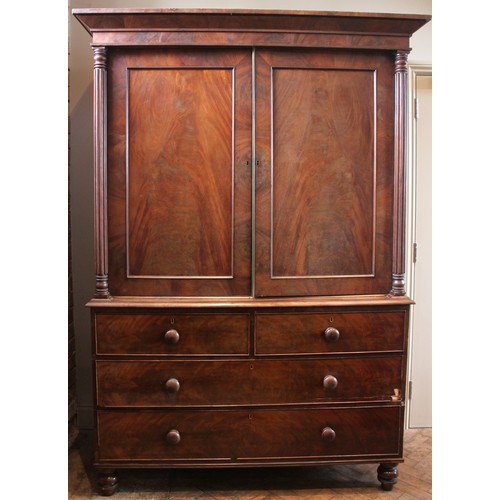 954 - A William IV mahogany linen press, the moulded cornice over a pair of flame mahogany doors opening t... 