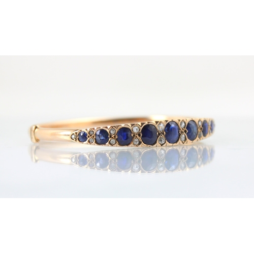 100 - A late 19th century untested sapphire and diamond bangle, the graduated untested sapphire (majority ... 