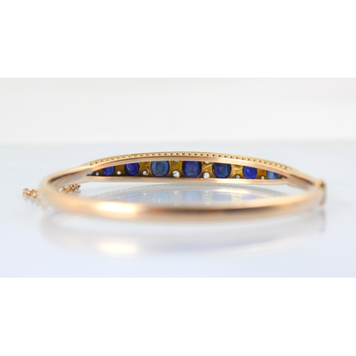 100 - A late 19th century untested sapphire and diamond bangle, the graduated untested sapphire (majority ... 