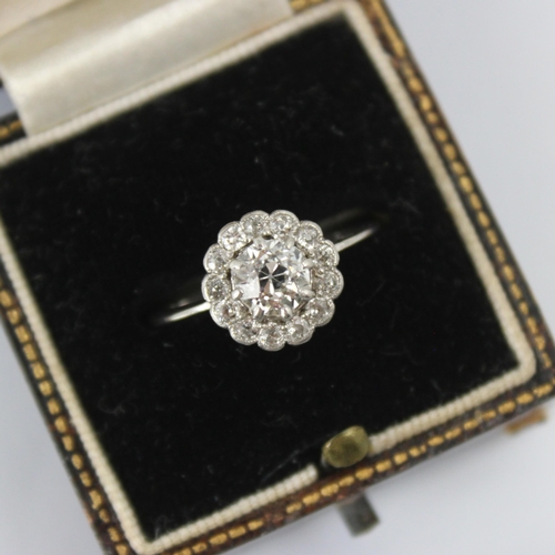 101 - An early 20th century diamond cluster ring, the central old cut diamond within a surround of thirtee... 