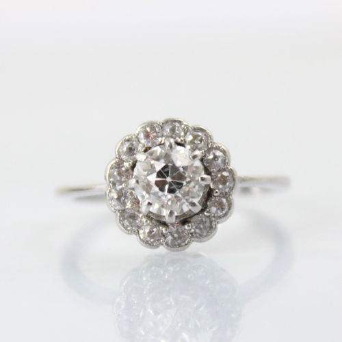 101 - An early 20th century diamond cluster ring, the central old cut diamond within a surround of thirtee... 