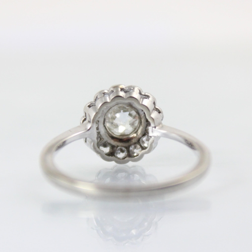 101 - An early 20th century diamond cluster ring, the central old cut diamond within a surround of thirtee... 