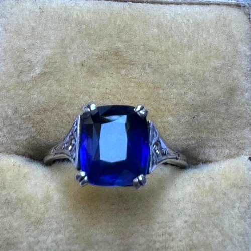 121 - An early 20th century Art Deco sapphire and diamond ring, the central cushion cut sapphire with doub... 