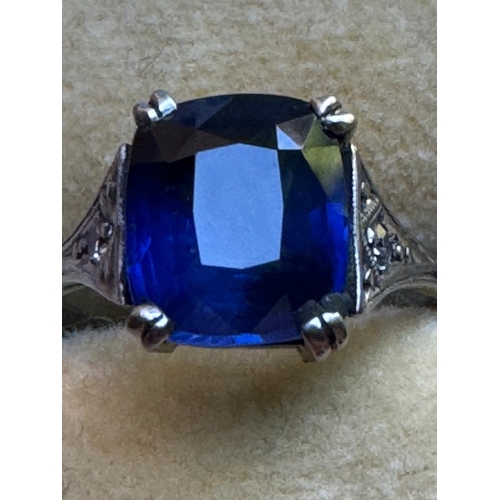 121 - An early 20th century Art Deco sapphire and diamond ring, the central cushion cut sapphire with doub... 