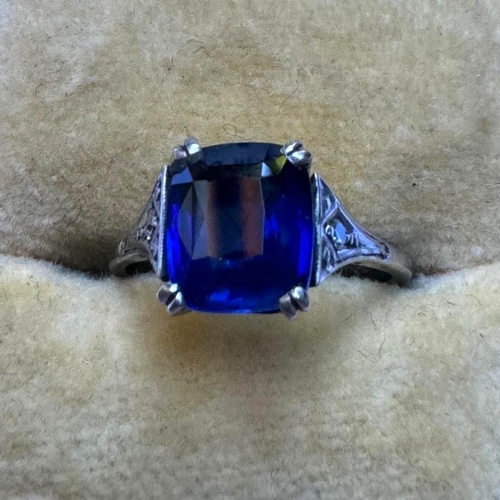 121 - An early 20th century Art Deco sapphire and diamond ring, the central cushion cut sapphire with doub... 