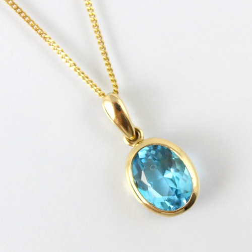 124 - An untested blue topaz pendant, the oval cut blue stone within 9ct yellow gold rub over mount, stamp... 