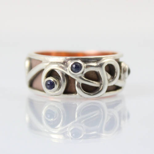 125 - A Clogau yellow metal and silver dress ring, the ‘Tree of life’ style ring with three blue stone cab... 