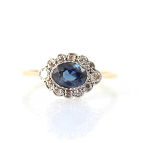 128 - An early 20th century untested sapphire and diamond set stylised cluster ring, the central untested ... 