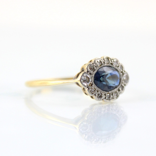 128 - An early 20th century untested sapphire and diamond set stylised cluster ring, the central untested ... 