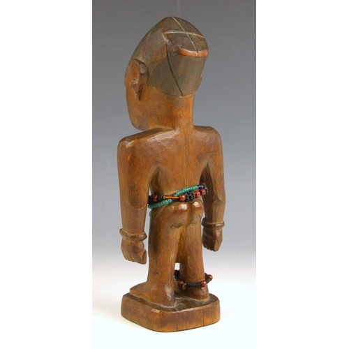 352 - A Nigerian carved wooden Yoruba Ibeji male figure, of typical form, decorated with beads, 26cm high