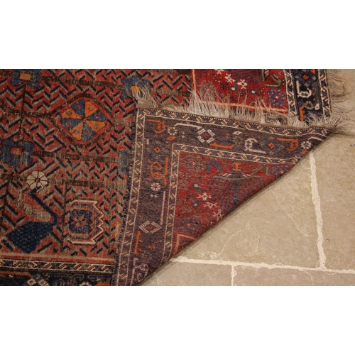 392 - A hand woven village wool rug, possibly Afghan, in red, blue, orange, and brown colourways, the cent... 