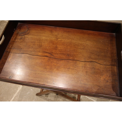 469 - A 19th century mahogany butler's tray and stand, the tray with a three quarter gallery and hand aper... 