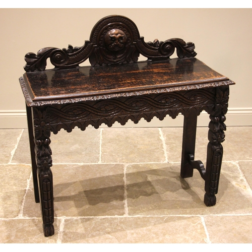 476 - A Victorian carved oak hall or side table, the openwork rear gallery centred with a relief carved ma... 