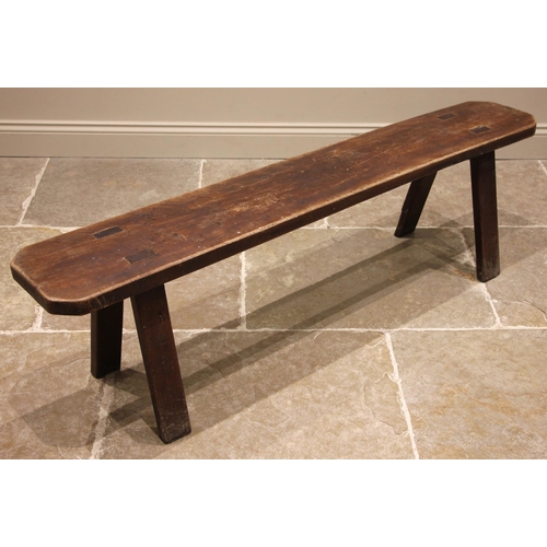 486 - A rustic ash bench, 19th century, the slab top with canted corners, upon tapering and splayed suppor... 