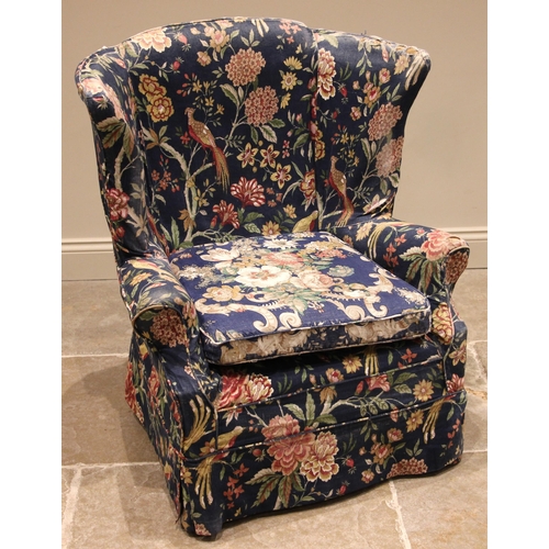 498 - An early 20th century barrel back armchair, with outswept wing backs extending to upholstered scroll... 