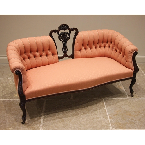 501 - An Edwardian mahogany sofa, later re-covered in coral coloured fabric, the central openwork splat ex... 