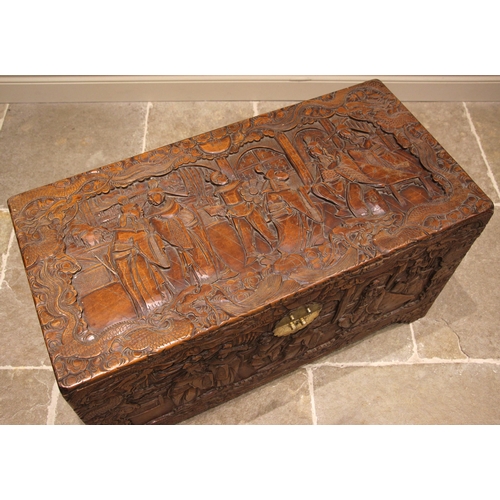 504 - A Chinese carved camphor wood chest, mid 20th century, the hinged cover carved in deep relief depict... 