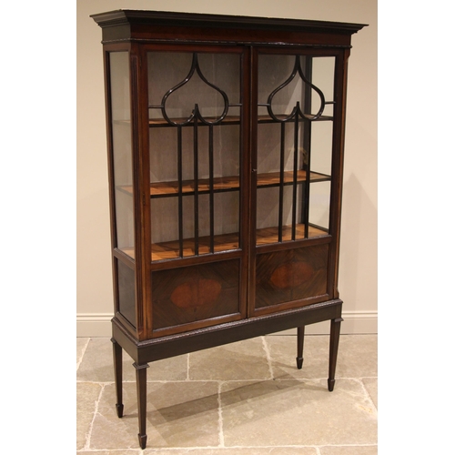 505 - An Edwardian mahogany display cabinet, the moulded dentil cornice over a pair of glazed doors applie... 