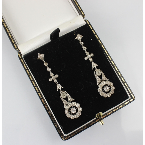 68 - A pair of early 20th century diamond drop earrings, the stylised flowerhead set with eleven round cu... 