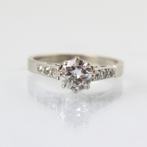 70 - A 20th century diamond solitaire ring, the round cut diamond within white metal eight claw setting e... 